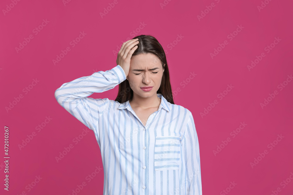 Young woman suffering from headache on pink background Young woman suffering from headache on pink background