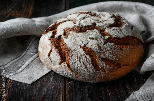 Homemade rye bread. Rye bread in a round shape on a wooden background in a rustic style with towel