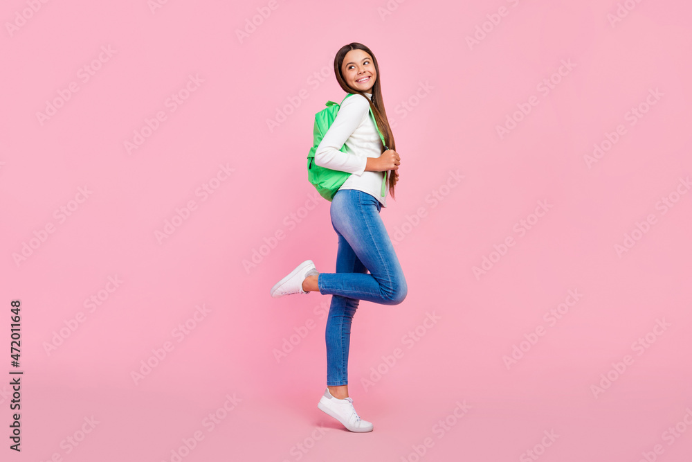Full size profile photo of smart brunette little girl look promo wear sweater bag jeans shoes isolated on pink color background