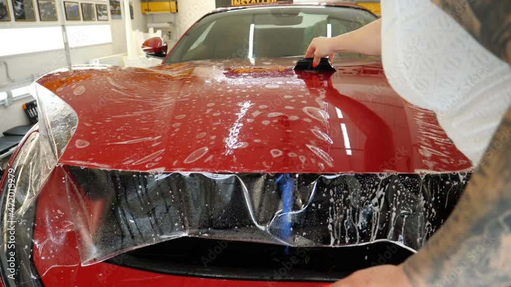 Close up to PPF installation process on a front headlight and hood. PPF