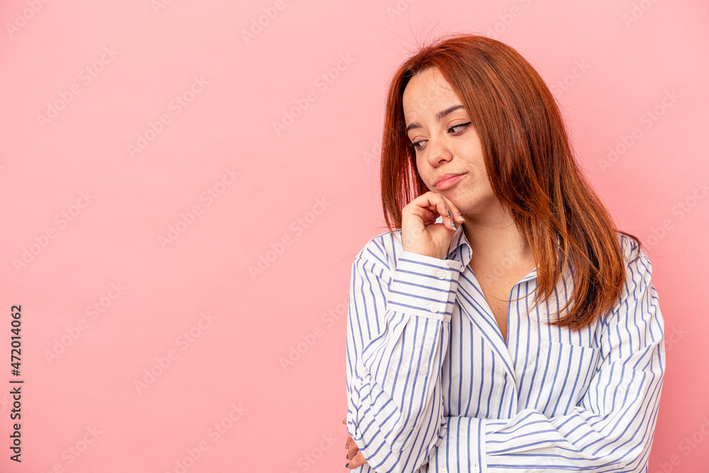 Young caucasian woman isolated on pink background looking sideways with doubtful and skeptical expression. Young caucasian woman isolated on pink background looking sideways with doubtful and skeptical expression.