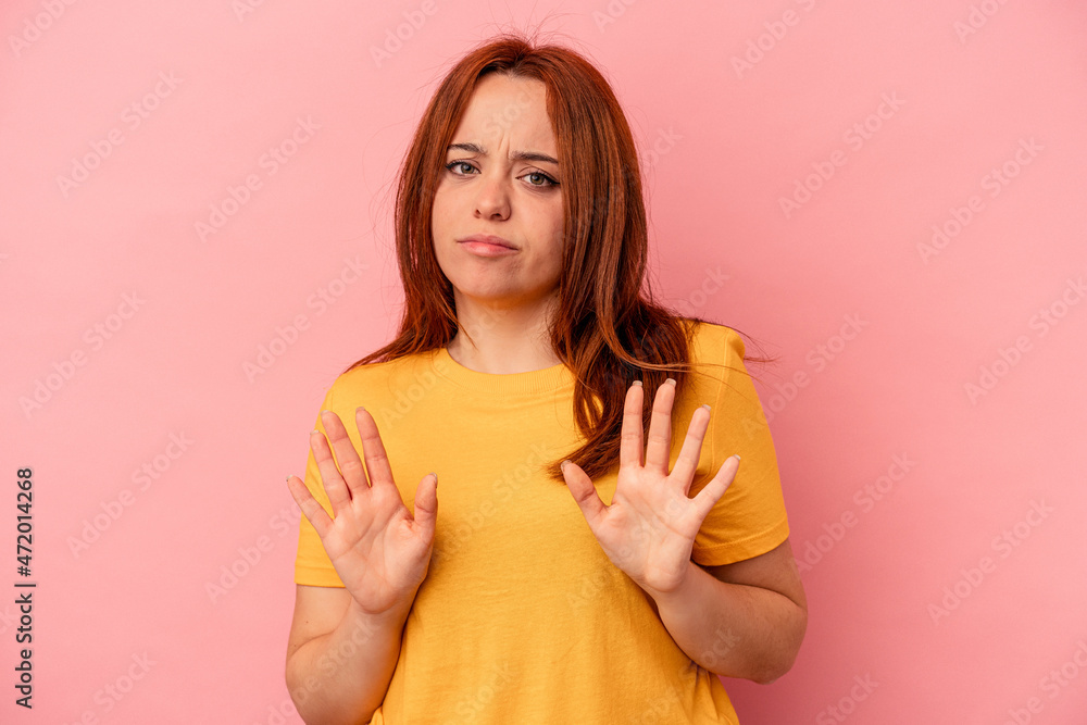 Young caucasian woman isolated on pink background rejecting someone showing a gesture of disgust. Young caucasian woman isolated on pink background rejecting someone showing a gesture of disgust.