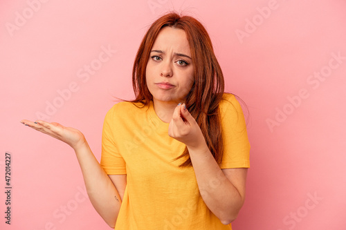 Young caucasian woman isolated on pink background showing that she has no money.