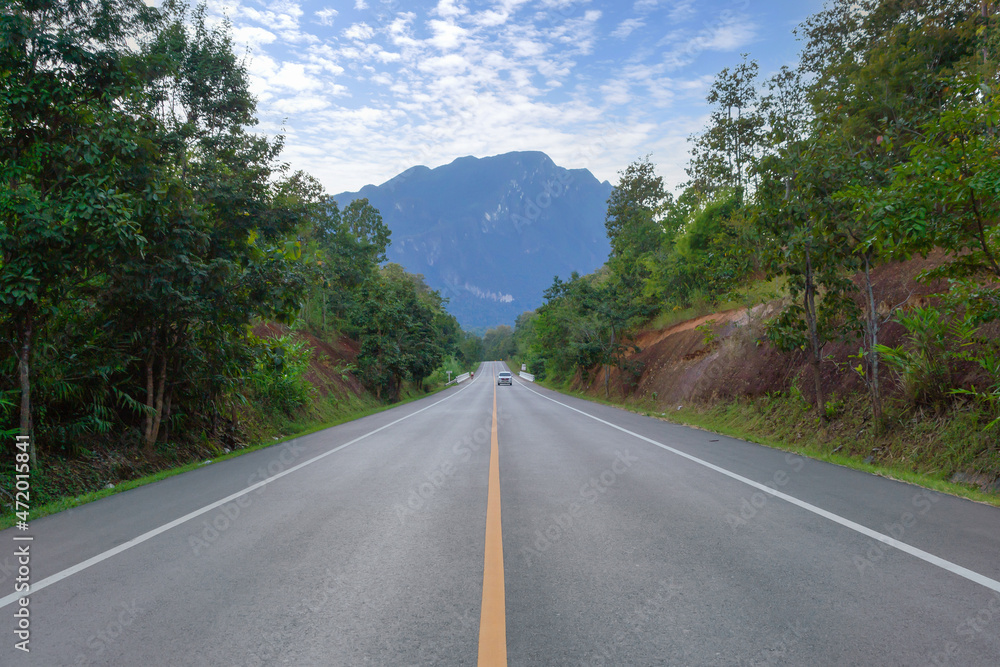 Fototapeta premium Empty road or street to Doi Luang Chiang Dao, Chiang Mai on mountain hill with green natural forest trees in rural area, Thailand. Transportation. Nature landscape background