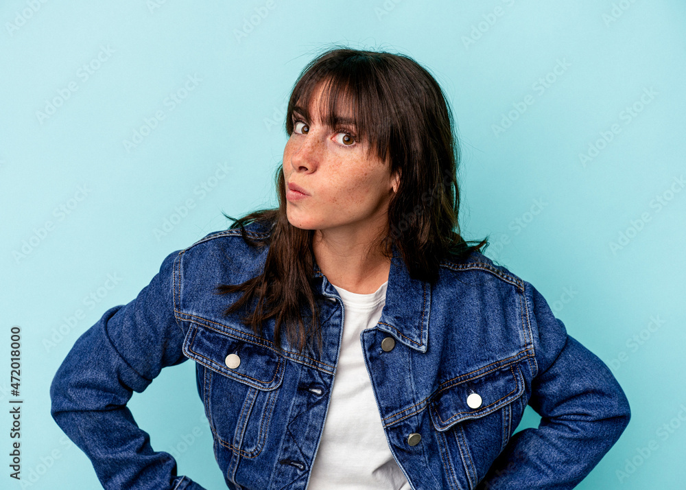 Young Argentinian woman isolated on blue background confused, feels doubtful and unsure. Young Argentinian woman isolated on blue background confused, feels doubtful and unsure.