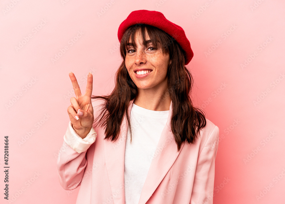 Young Argentinian woman isolated on pink background joyful and carefree showing a peace symbol with fingers. Young Argentinian woman isolated on pink background joyful and carefree showing a peace symbol with fingers.