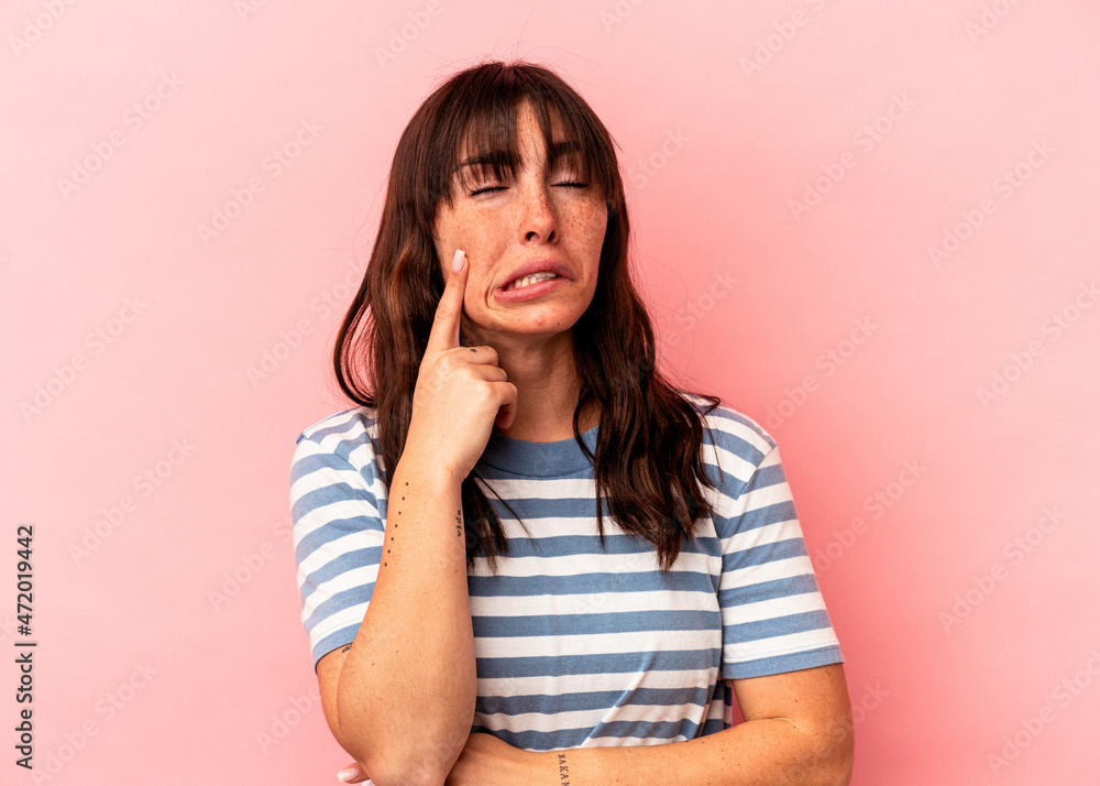 Young Argentinian woman isolated on pink background crying, unhappy with something, agony and confusion concept. Young Argentinian woman isolated on pink background crying, unhappy with something, agony and confusion concept.
