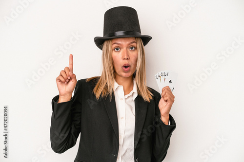 Young caucasian wizard woman holding magic card isolated on white background having some great idea, concept of creativity.