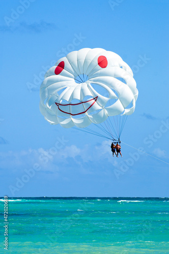 White parasailing  with 2 people towed at beach in Punta Cana