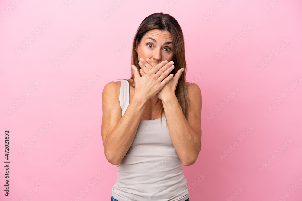 Middle age caucasian woman isolated on pink background covering mouth with hands Middle age caucasian woman isolated on pink background covering mouth with hands