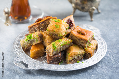 Traditional Turkish Desserts Baklava with  Tea. Crispy mix baklava on silver  plate. photo