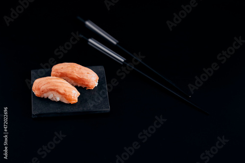 various salmon sushi on a black plate