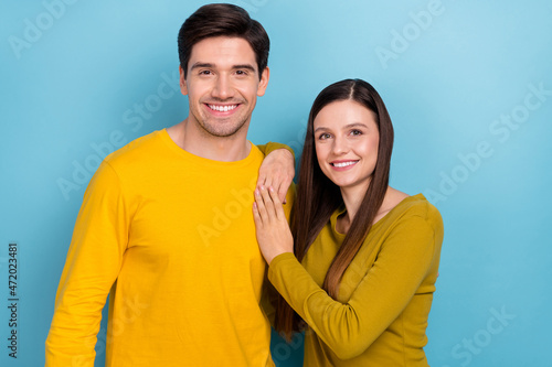 Photo of cheerful romantic couple cuddle posing wear yellow casual outfit isolated blue color background