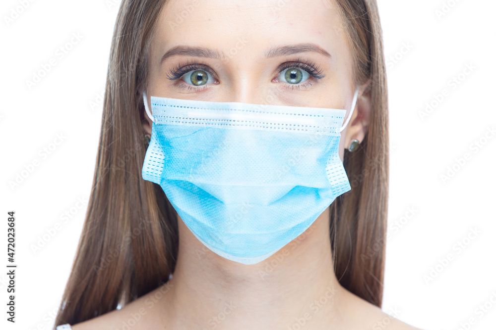 Closeup portrait of a young woman wearing a face mask under stress from coronavirus disease, looking at camera, isolated on white background. Flu epidemic, dust allergy, protection against virus