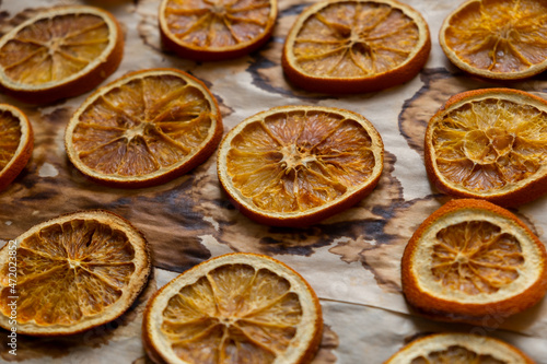 Dried oranges flat lay top view. Background of natural dried oranges on baking paper. The concept of preparing for the holiday, Christmas decorations. Natural toys, eco-design. A sustainable lifestyle