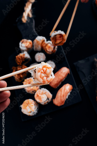 table black various sushi with hand on hashi