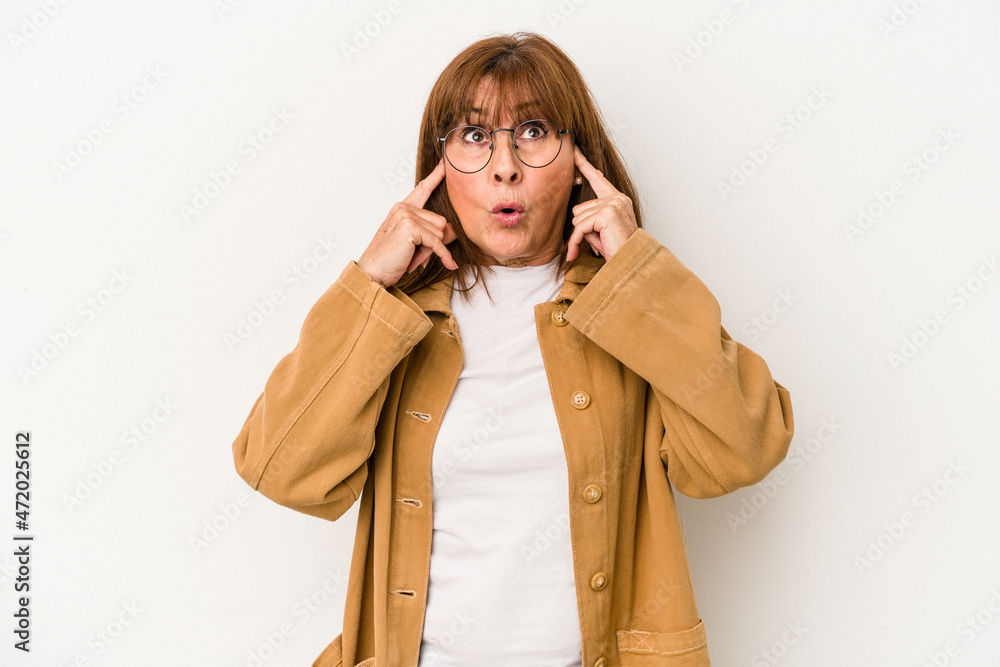 Middle age caucasian woman isolated on white background covering ears with fingers, stressed and desperate by a loudly ambient. Middle age caucasian woman isolated on white background covering ears with fingers, stressed and desperate by a loudly ambient.