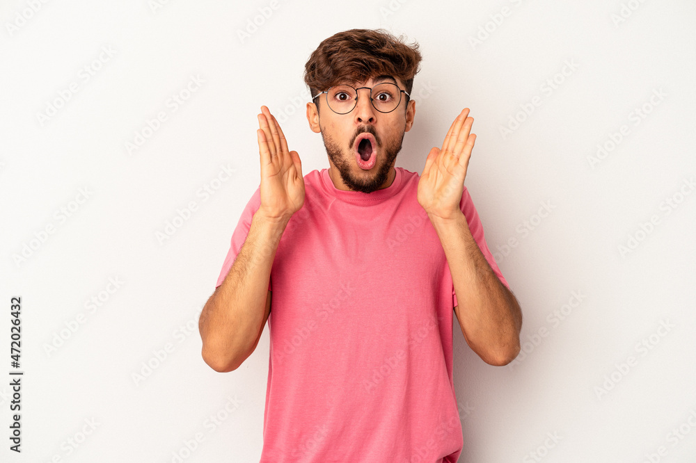 Young mixed race man isolated on grey background surprised and shocked. Young mixed race man isolated on grey background surprised and shocked.