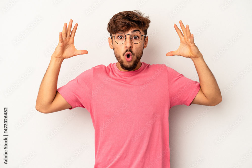 Young mixed race man isolated on grey background celebrating a victory or success, he is surprised and shocked. Young mixed race man isolated on grey background celebrating a victory or success, he is surprised and shocked.