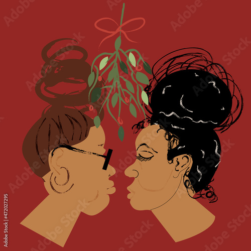 Lesbian couple kissing under the mistletoe