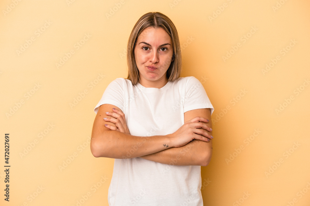Obraz premium Young caucasian woman isolated on yellow background shrugs shoulders and open eyes confused.