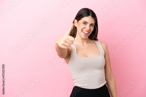 Young Italian woman isolated on pink background with thumbs up because something good has happened