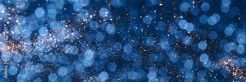 Blue and golden sparkling glitter bokeh background, christmas texture. Holiday lights. Abstract defocused header. Wide screen wallpaper. Panoramic web banner with copy space for design
