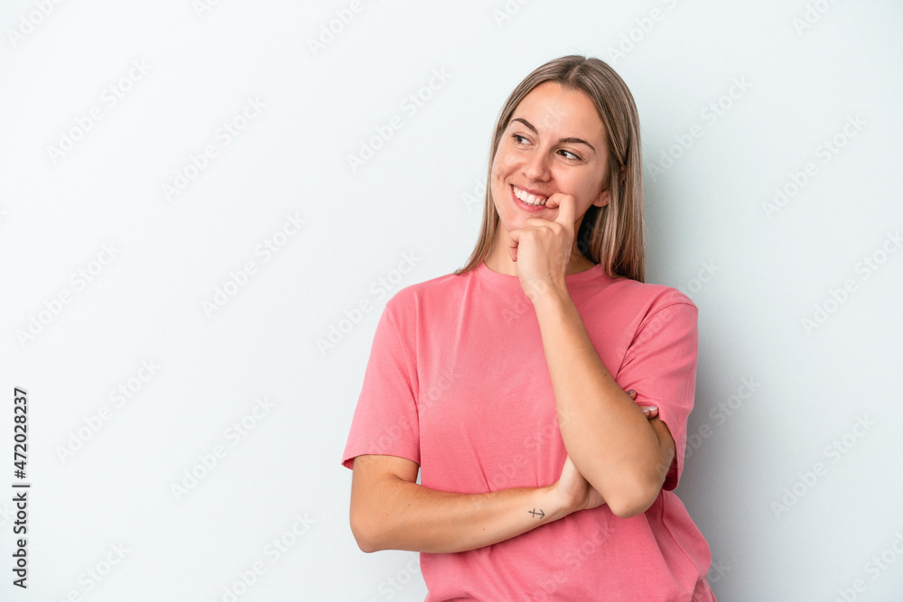 Young caucasian woman isolated on blue background relaxed thinking about something looking at a copy space. Young caucasian woman isolated on blue background relaxed thinking about something looking at a copy space.