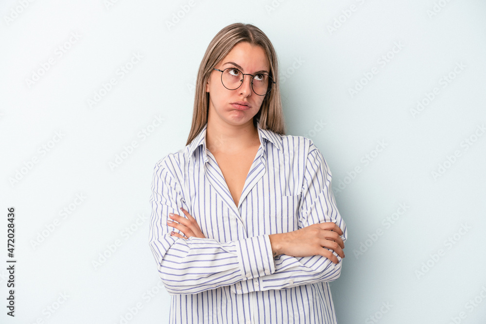 Young caucasian woman isolated on blue background tired of a repetitive task. Young caucasian woman isolated on blue background tired of a repetitive task.