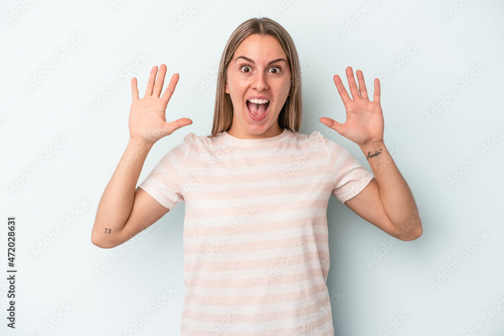 Young caucasian woman isolated on blue background receiving a pleasant surprise, excited and raising hands. Young caucasian woman isolated on blue background receiving a pleasant surprise, excited and raising hands.