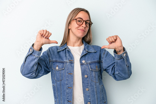 Young caucasian woman isolated on blue background feels proud and self confident, example to follow. photo