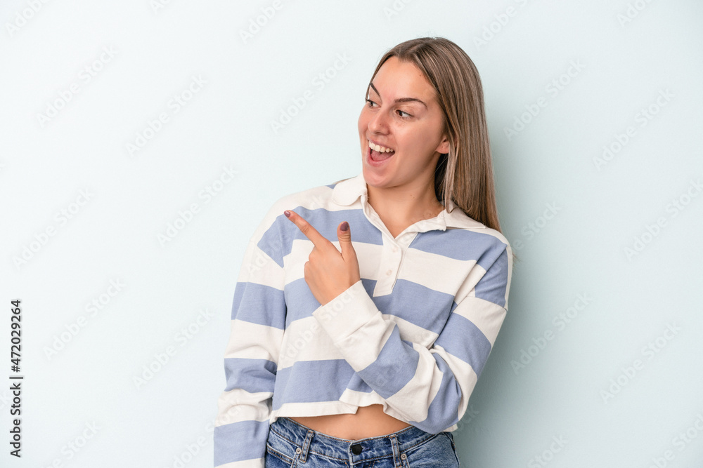 Young caucasian woman isolated on blue background looks aside smiling, cheerful and pleasant. Young caucasian woman isolated on blue background looks aside smiling, cheerful and pleasant.