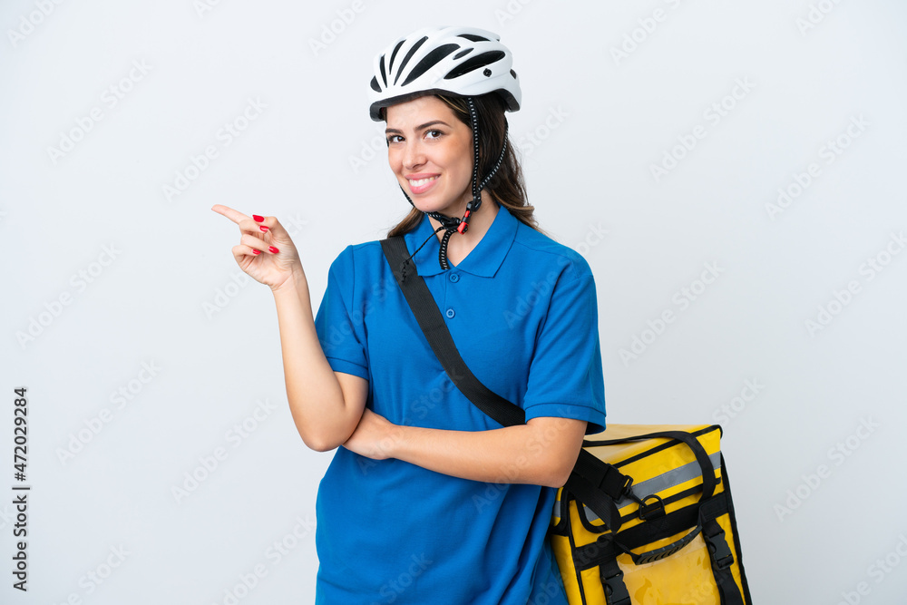 Young delivery woman with thermal backpack isolated on white background pointing finger to the side Young delivery woman with thermal backpack isolated on white background pointing finger to the side
