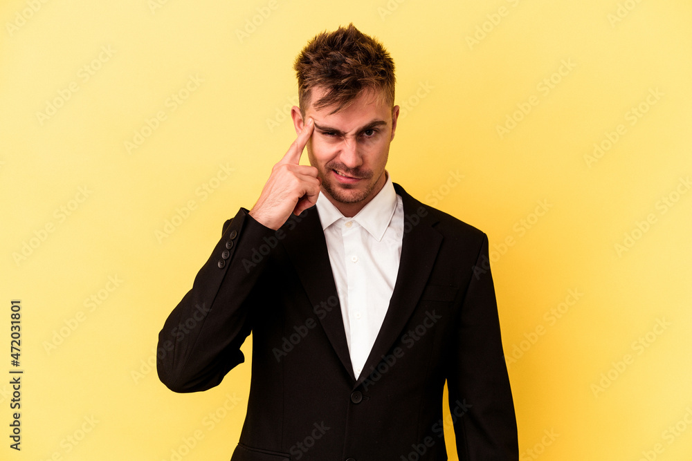Young caucasian business man isolated on yellow background showing a disappointment gesture with forefinger. Young caucasian business man isolated on yellow background showing a disappointment gesture with forefinger.