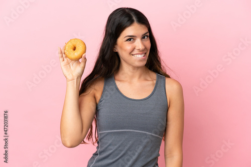 Young caucasian woman isolated on pink background holding donuts