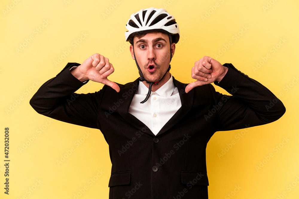Young caucasian business man wearing a bike helmet isolated on yellow background feels proud and self confident, example to follow. Young caucasian business man wearing a bike helmet isolated on yellow background feels proud and self confident, example to follow.