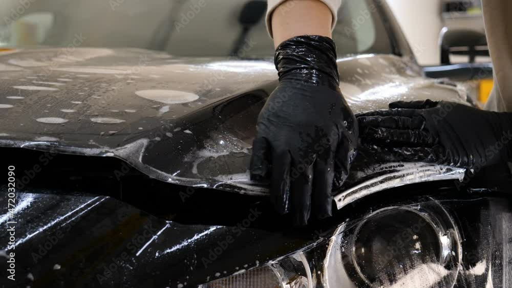 Close up to PPF installation process on a front headlight and hood. PPF