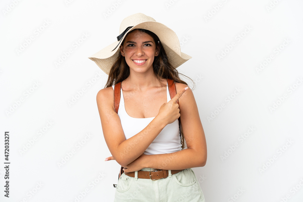 Young caucasian woman wearing a Pamela in summer holidays isolated on white background pointing to the side to present a product Young caucasian woman wearing a Pamela in summer holidays isolated on white background pointing to the side to present a product