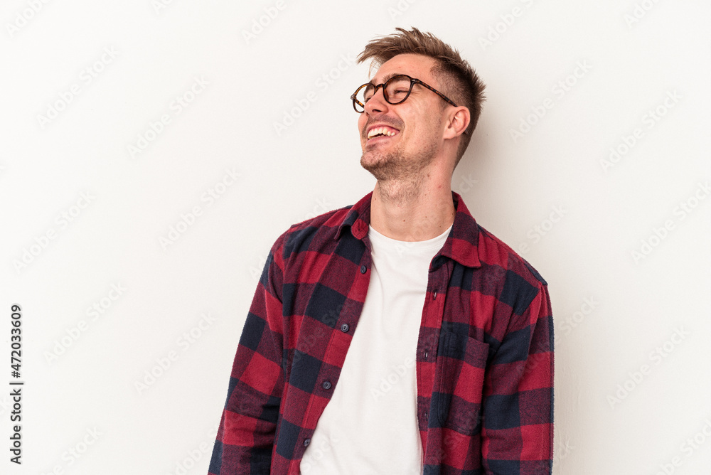 Young caucasian man isolated on white background relaxed and happy laughing, neck stretched showing teeth. Young caucasian man isolated on white background relaxed and happy laughing, neck stretched showing teeth.