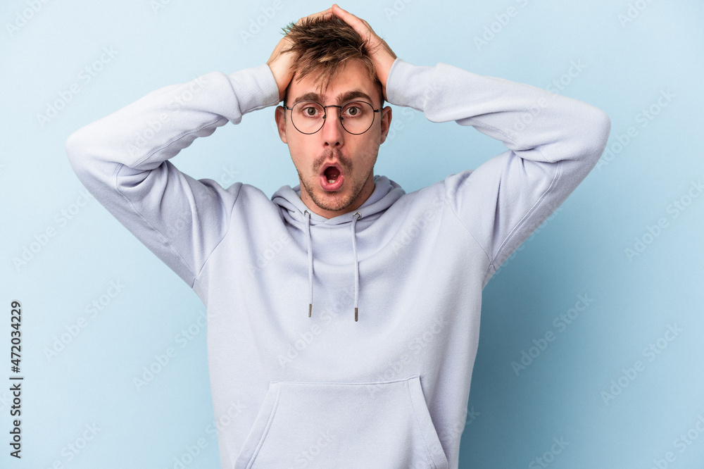 Young caucasian man isolated on blue background surprised and shocked. Young caucasian man isolated on blue background surprised and shocked.