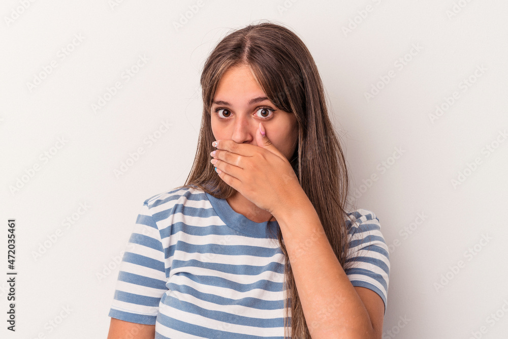 Young caucasian woman isolated on white background covering mouth with hands looking worried.