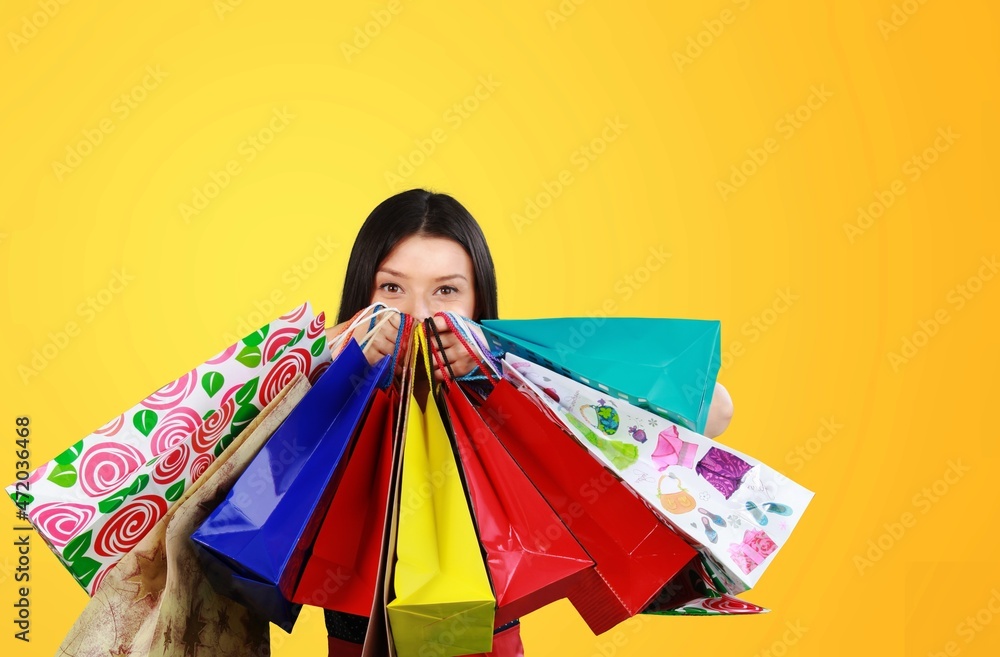 Photo of funny excited young woman holding bags