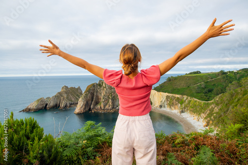 Back view of a woman outstretching arms on vacation