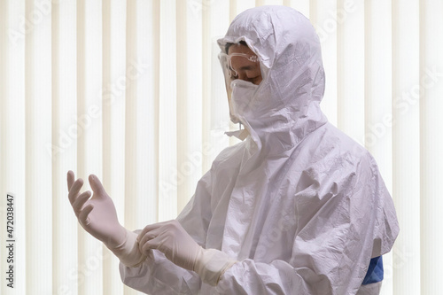 doctor wearing ppe suit and facemask perform coronavirus covid-19 PCR test. doctor puts on protective gloves for fighting new omicron covid.  photo