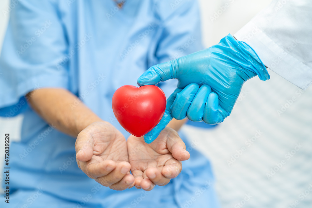 Doctor give red heart to Asian senior or elderly old lady woman patient, healthy strong medical concept Doctor give red heart to Asian senior or elderly old lady woman patient, healthy strong medical concept