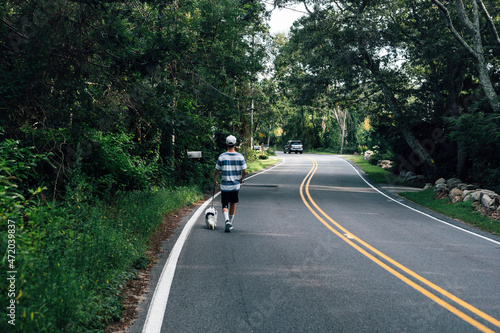 Man walking with Cavapoo dog on road photo