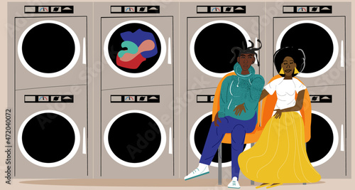Lesbian couple waiting for the clothes to dry at the laundromat