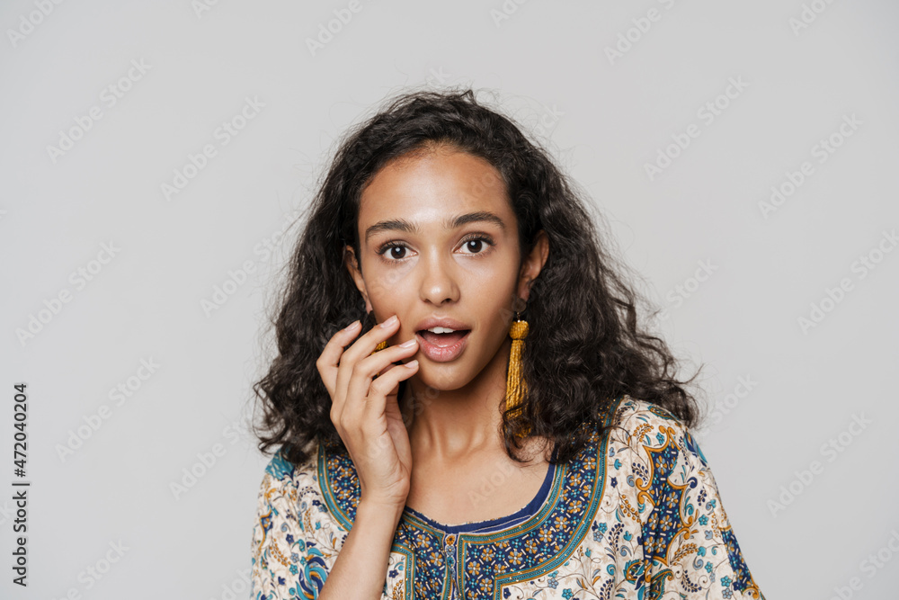 Young south asian woman wearing earrings expressing surprise at camera