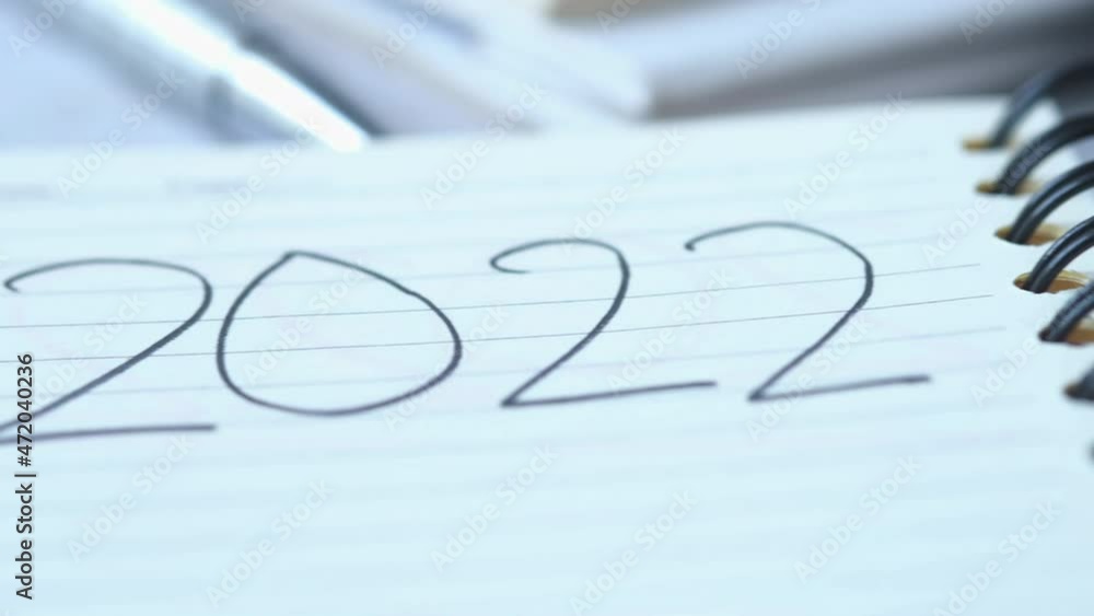 close up of 2022 new year goals on notepad on table close up of 2022 new year goals on notepad on table