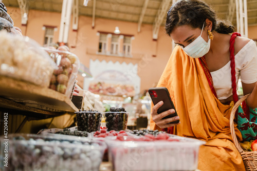 Photography Young indian woman using mobile phone during shopping in eastern market